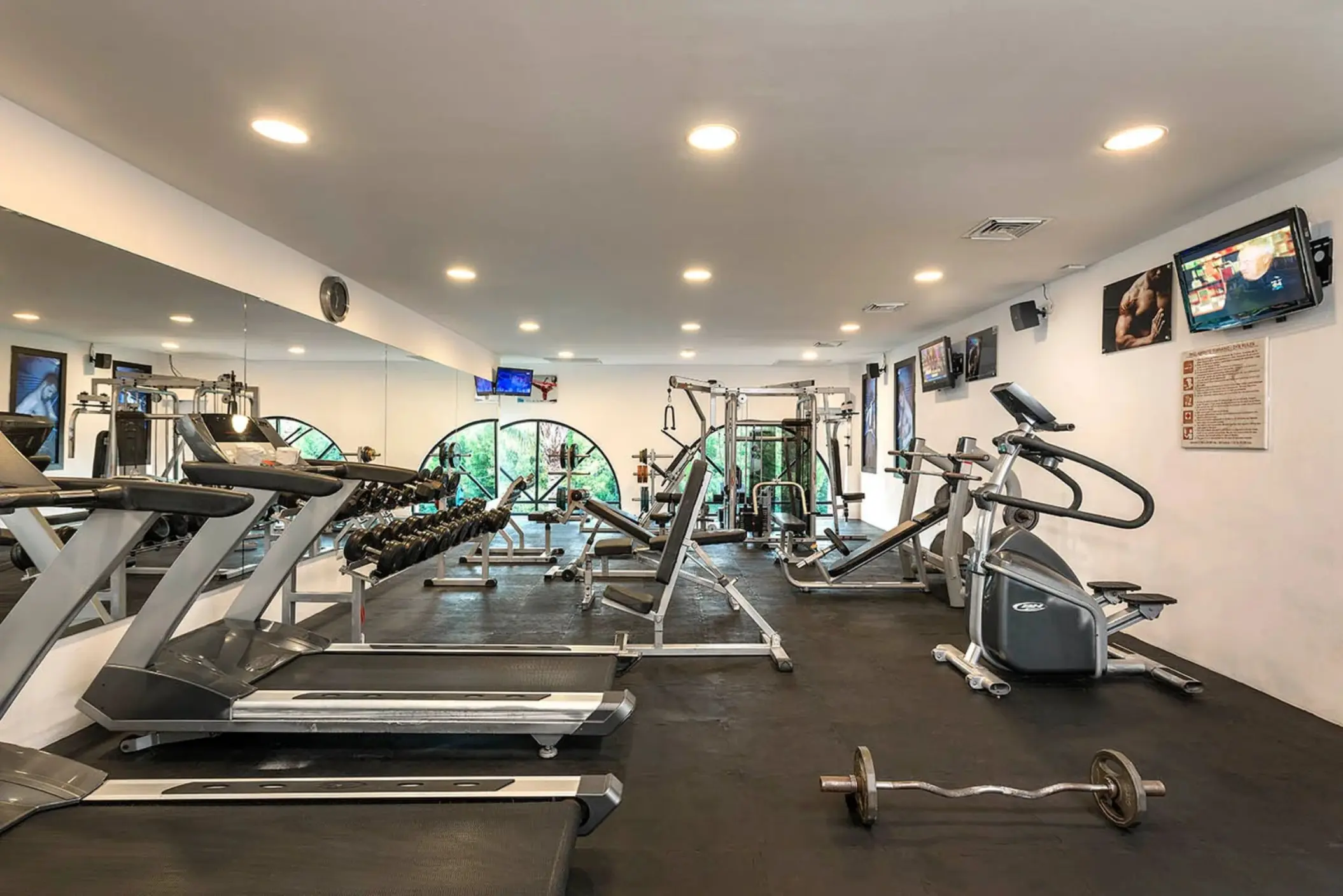 A well-equipped gym with treadmills, free weights, and various weight machines.