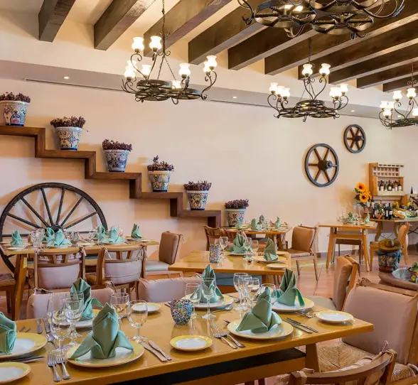 A restaurant with rustic, hacienda-style decor, including wooden beams and a large decorative fountain.