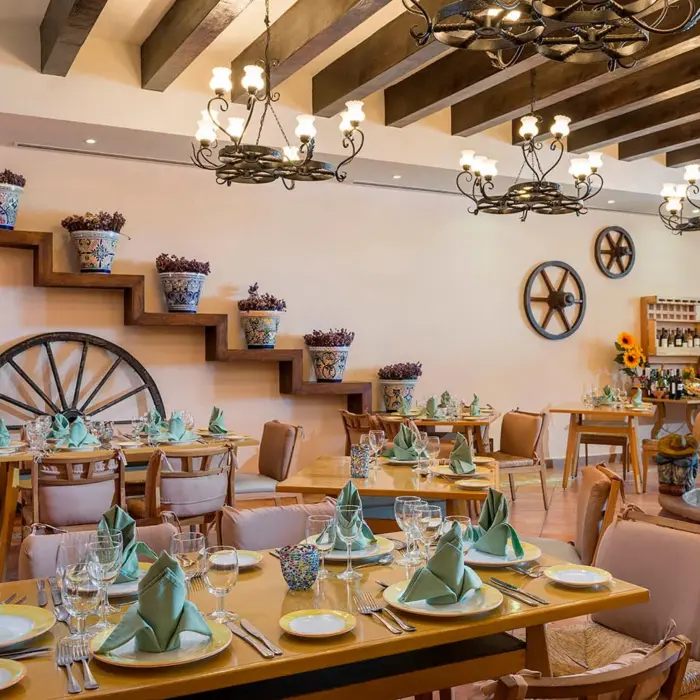 A restaurant with rustic, hacienda-style decor, including wooden beams and a large decorative fountain.