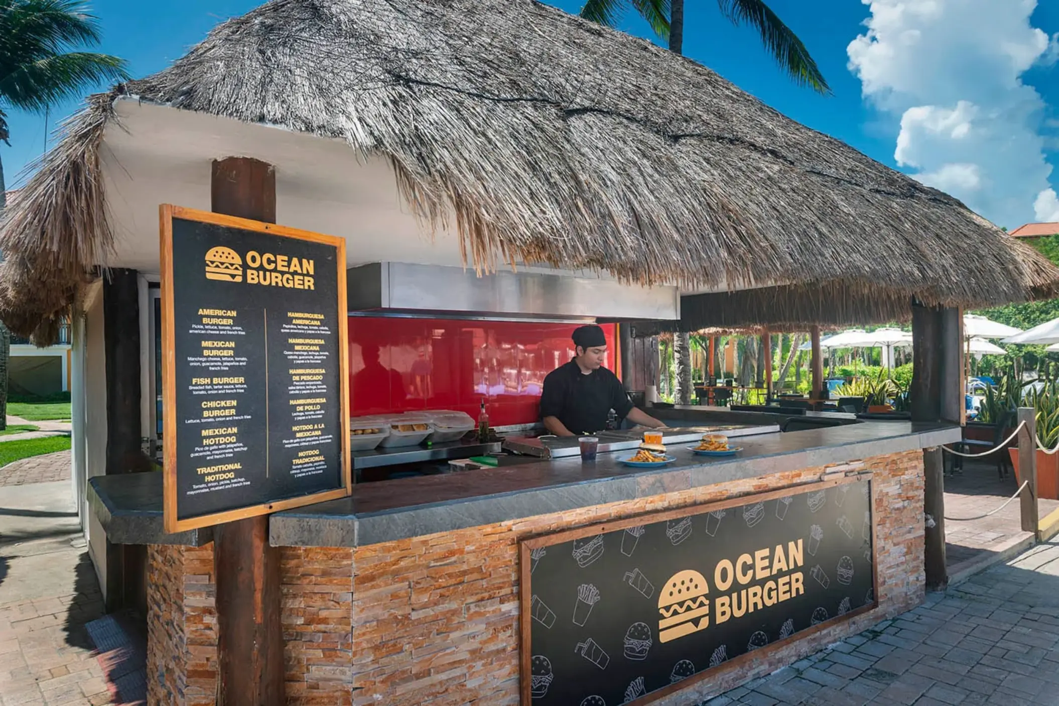 An outdoor food shack with a thatched roof and 