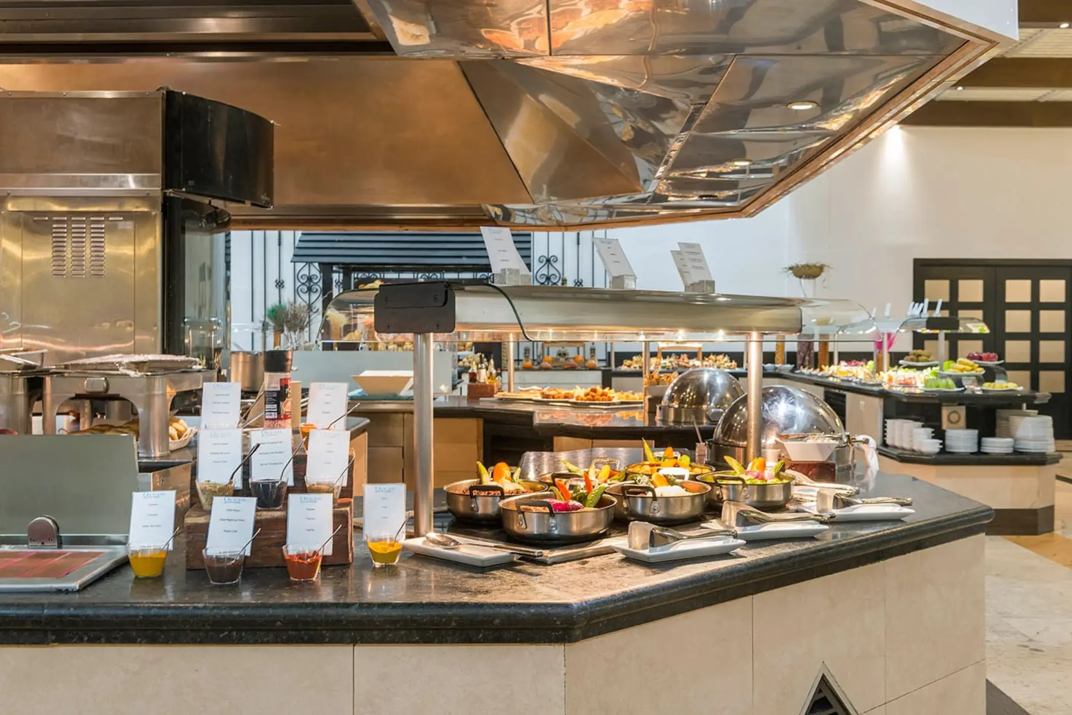 vibrant and well-stocked buffet restaurant with various food stations, fresh salads, and hot dishes under modern lighting.
