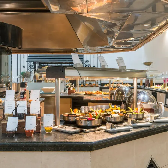 vibrant and well-stocked buffet restaurant with various food stations, fresh salads, and hot dishes under modern lighting.