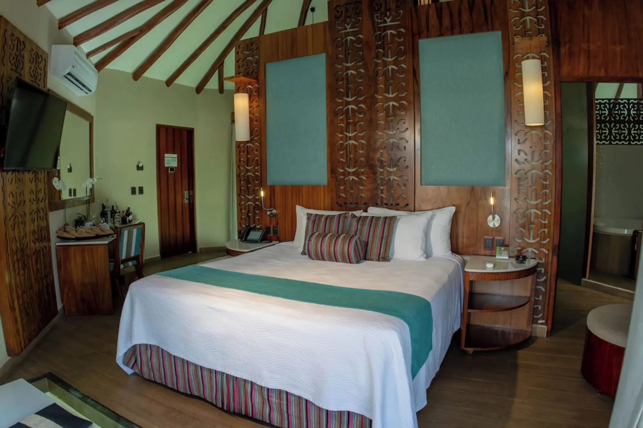 bungalow with comfortable bed and wooden accents at Palafitos Overwater Bungalows