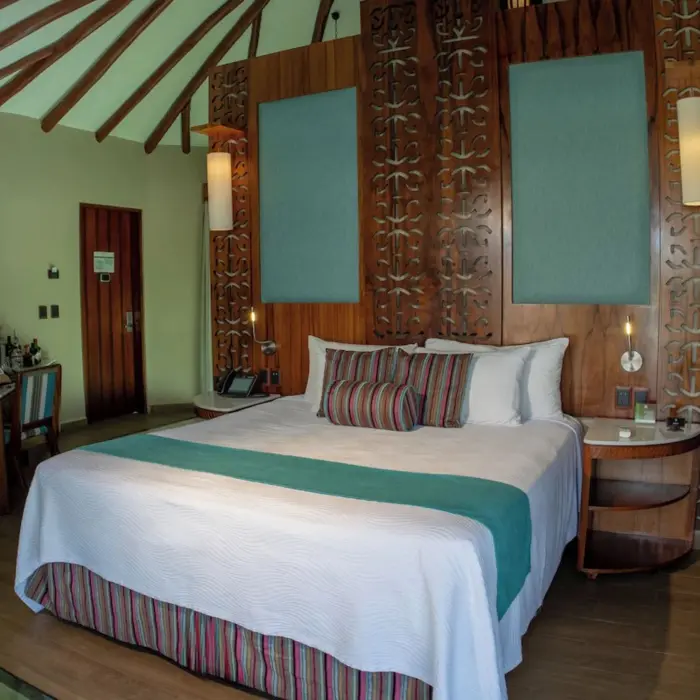 bungalow with comfortable bed and wooden accents at Palafitos Overwater Bungalows