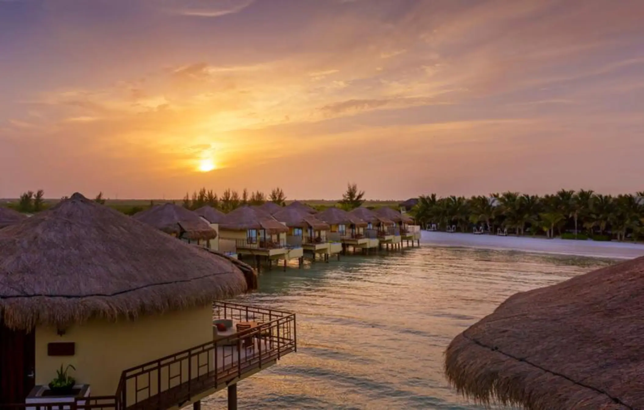 Palafitos Overwater Bungalows with the sun setting