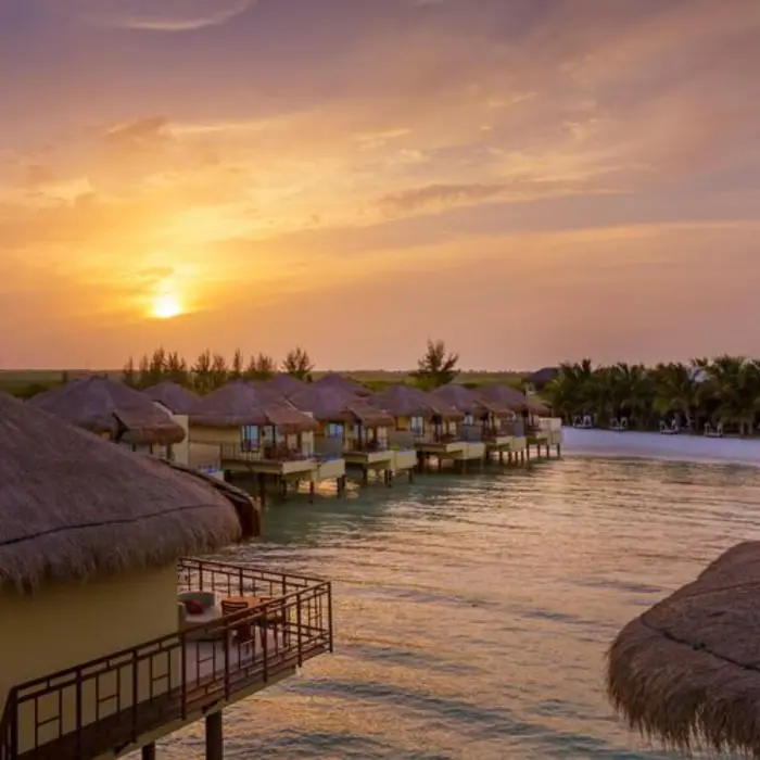 Palafitos Overwater Bungalows with the sun setting