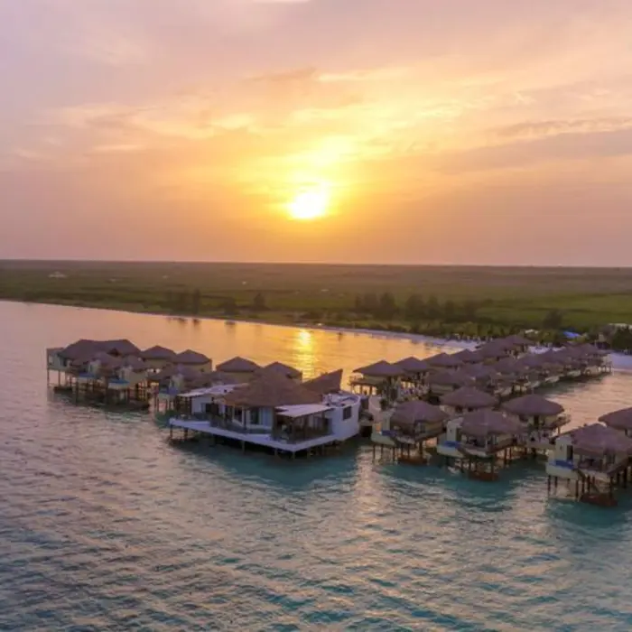 sun setting over Palafitos Overwater Bungalows and the sea