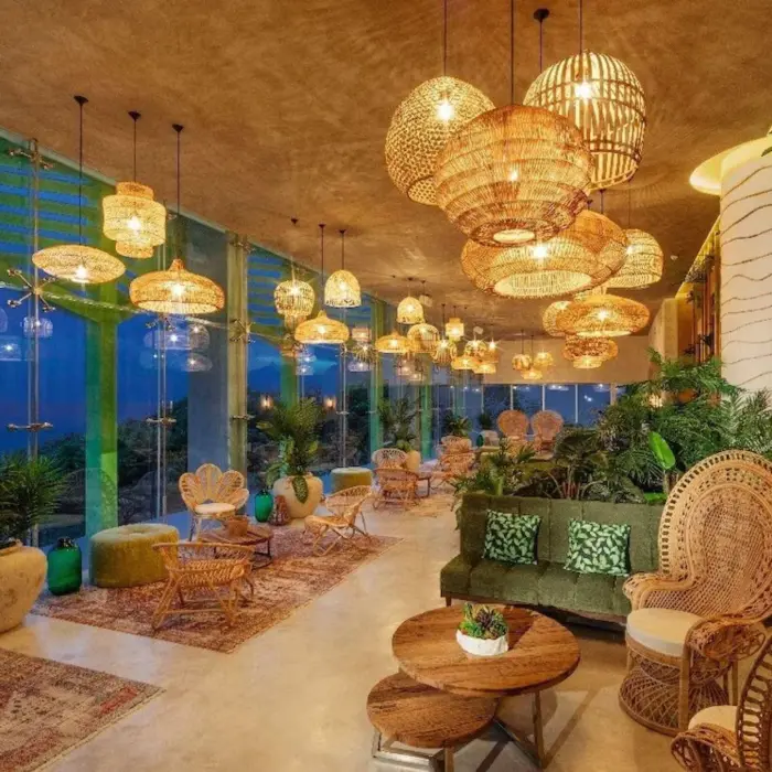 Cozy, plant-filled coffee shop with modern seating at Palmaïa - The House of AïA resort in Mexico