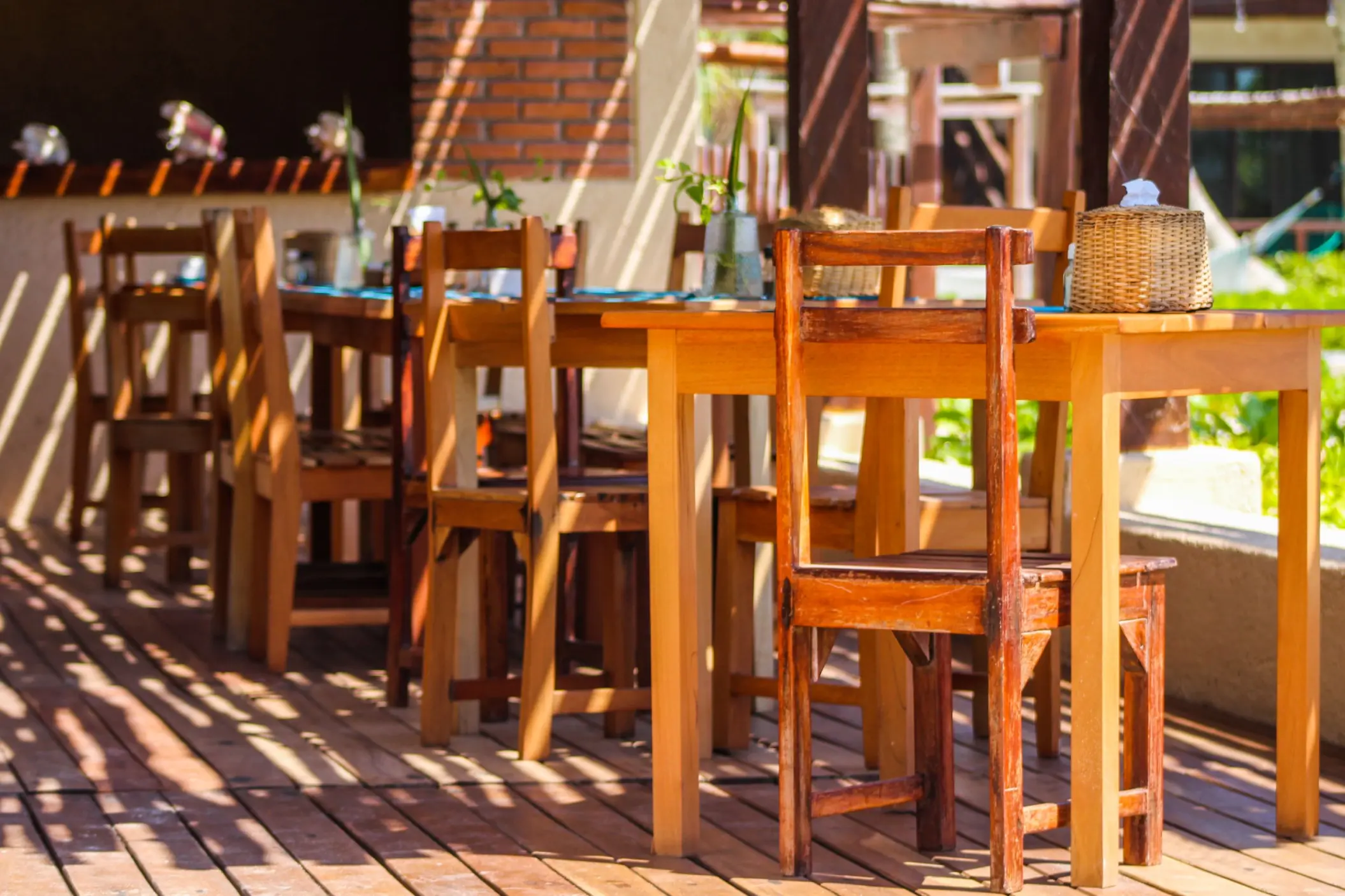 Outdoor dining area of Restaurant Molcajete at Piedra Escondida with wooden tables and chairs on a shaded deck.