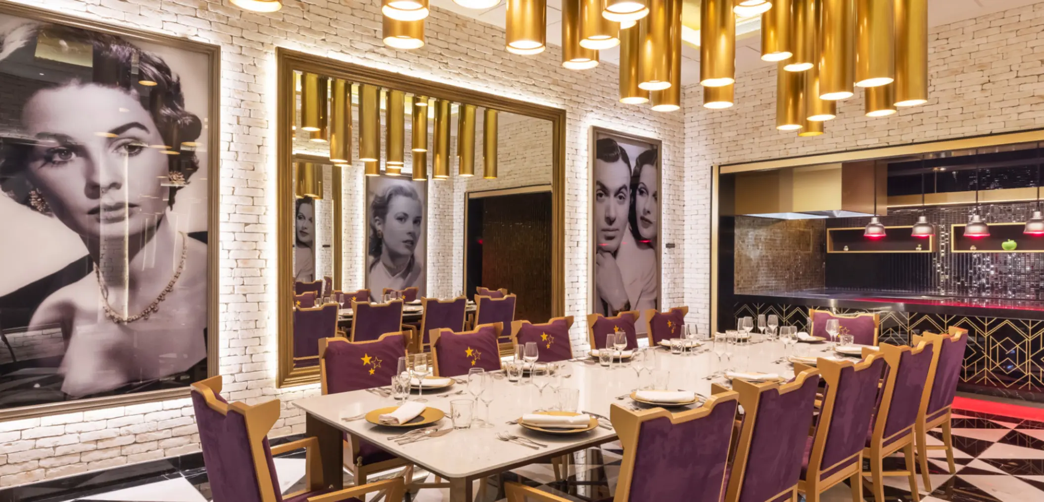 Elegant restaurant with gold lighting, vintage portraits, and purple velvet chairs set for a group dinner.