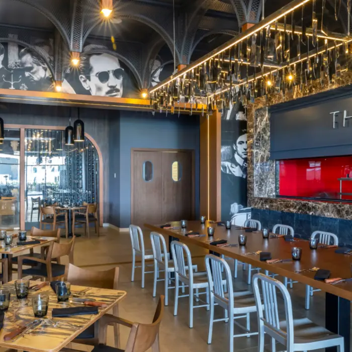 Movie-themed restaurant with black-and-white murals, wooden furniture, and “The Broiler” sign on wall.