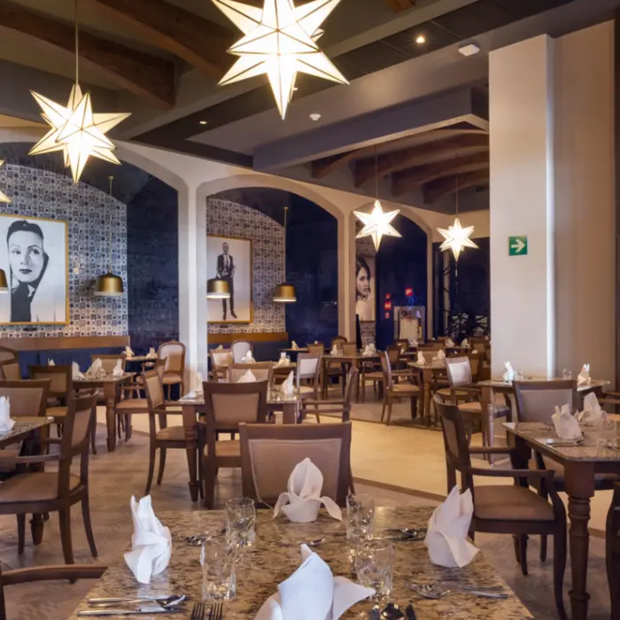Mexican-themed restaurant with blue tile walls, portraits of classic stars, and glowing star-shaped lights.