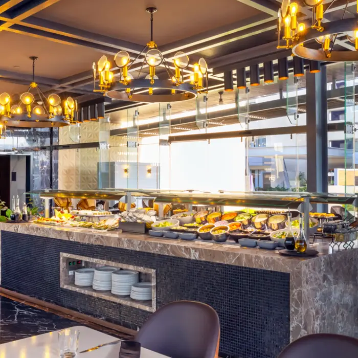 Buffet restaurant with marble counters, stylish lighting, and a variety of fresh dishes on display.