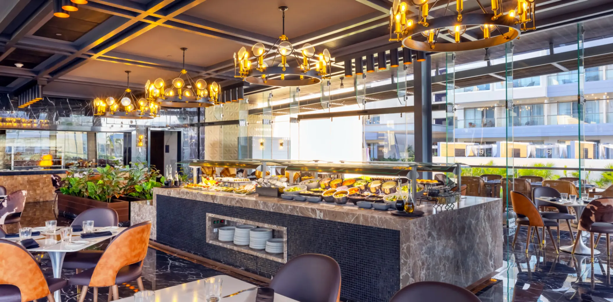 Buffet restaurant with marble counters, stylish lighting, and a variety of fresh dishes on display.