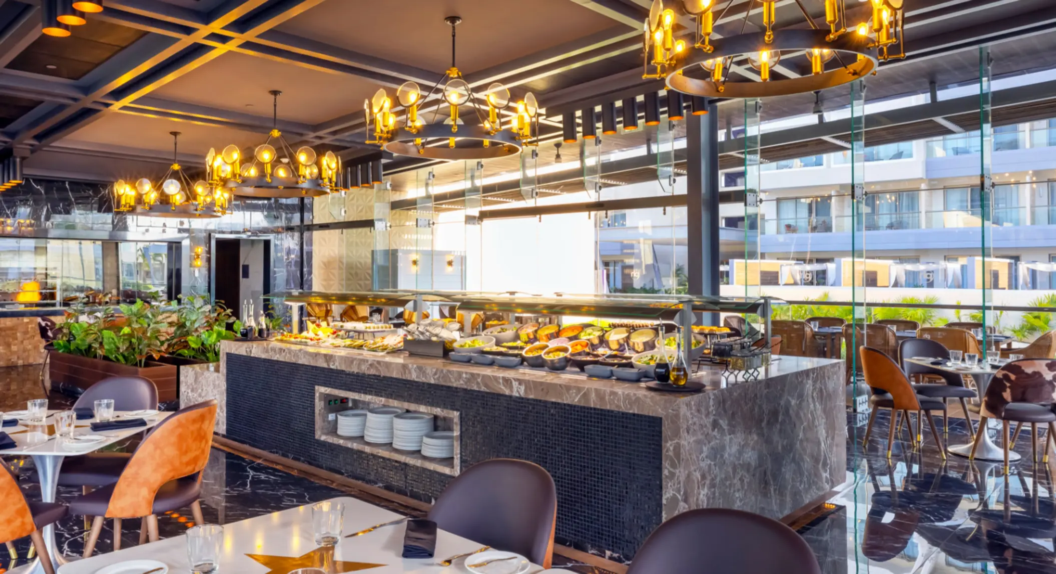 Upscale buffet restaurant with marble counters, modern lighting, and a variety of fresh dishes on display.