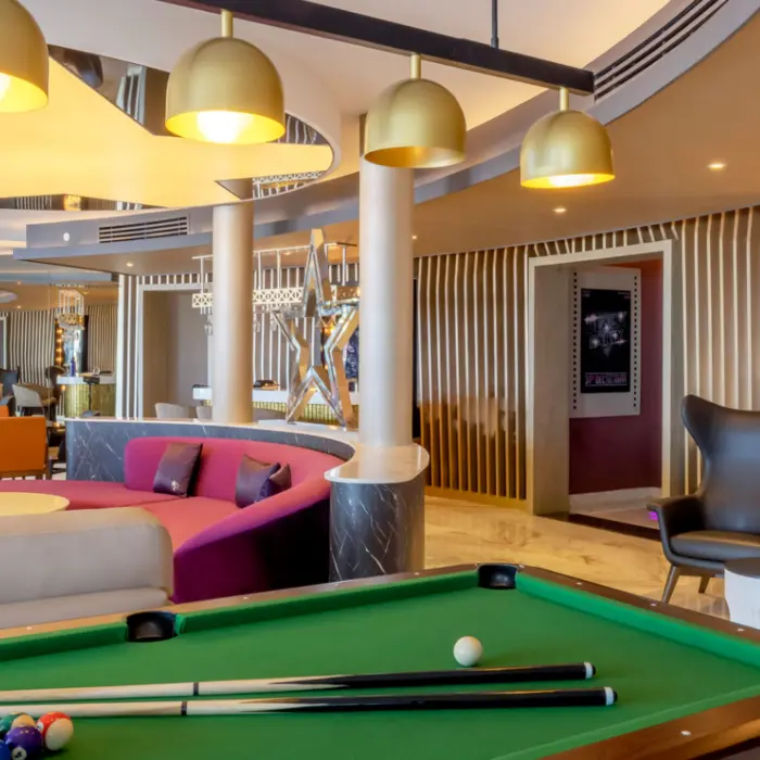 Stylish entertainment lounge with billiards, plush seating, Oscar-themed decor, and a cozy, cinematic ambiance.