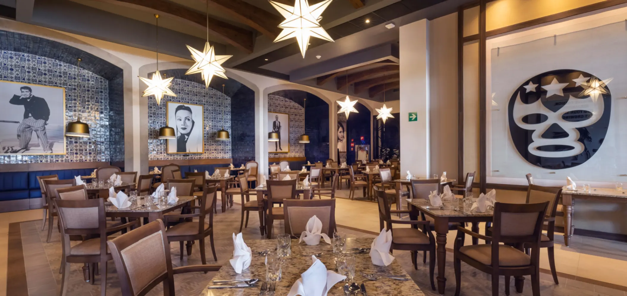 Mexican-style restaurant with tile walls, rustic wood decor, and portraits of classic film icons.