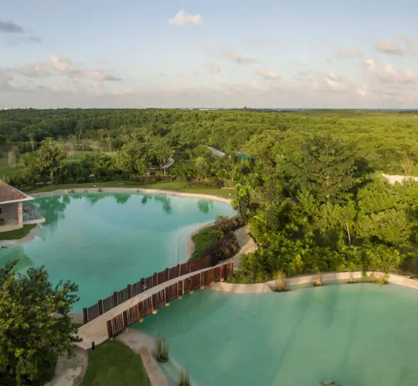 Aerial view of cenote-style pools surrounded by lush green jungle at the Platinum Yucatan Princess resort.