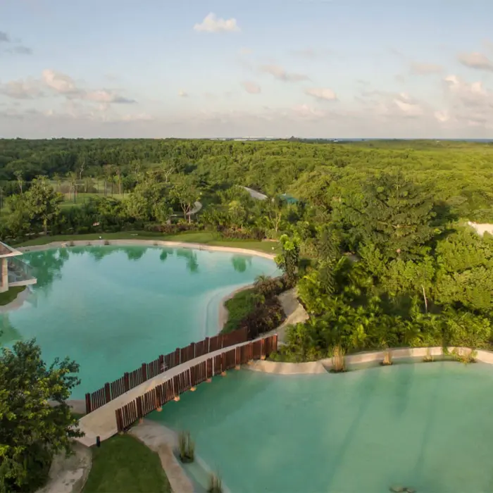 Aerial view of cenote-style pools surrounded by lush green jungle at the Platinum Yucatan Princess resort.