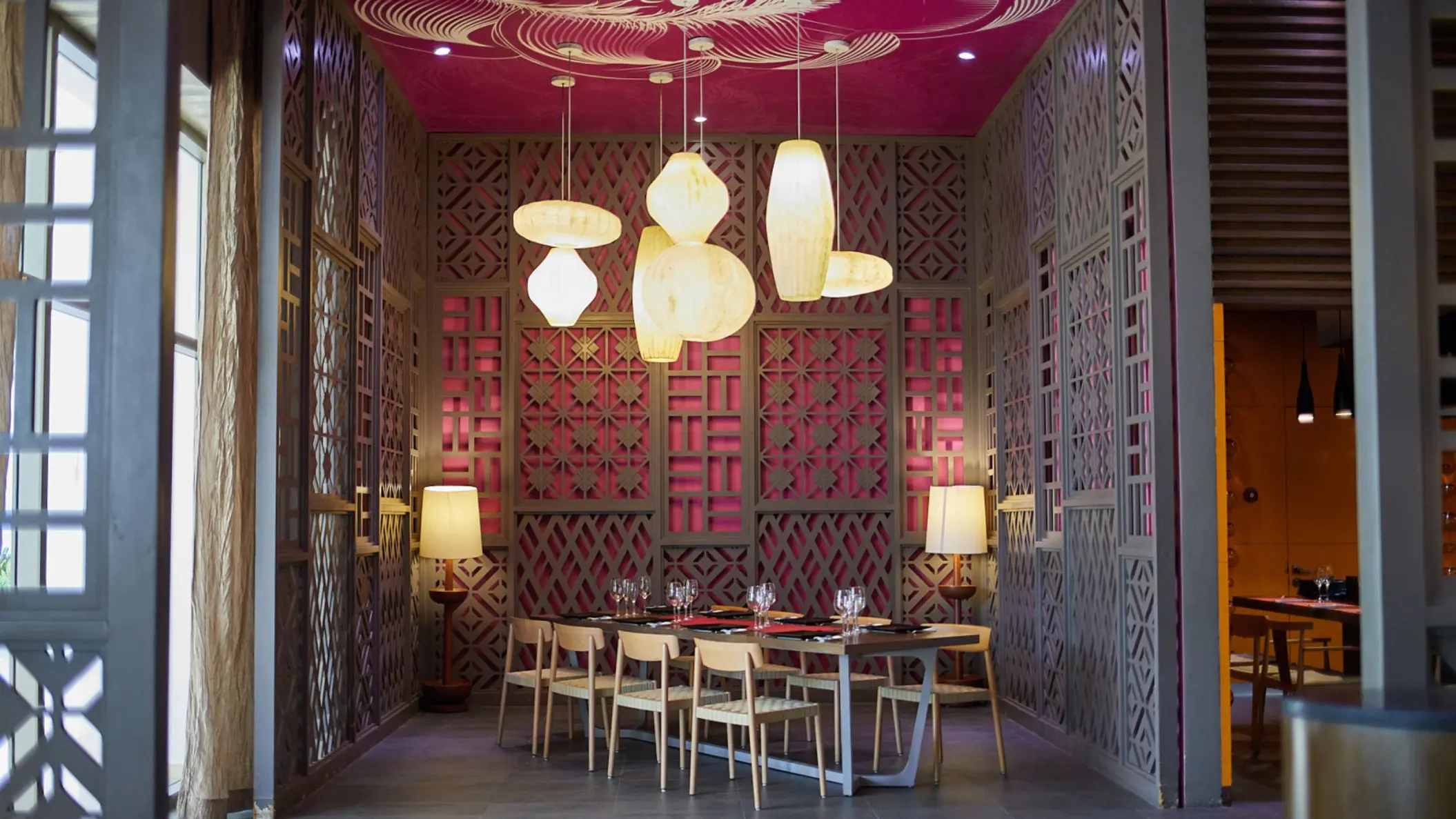 The Kotatsu restaurant dining area with unique lighting fixtures, pink decor, and wooden lattice screens.