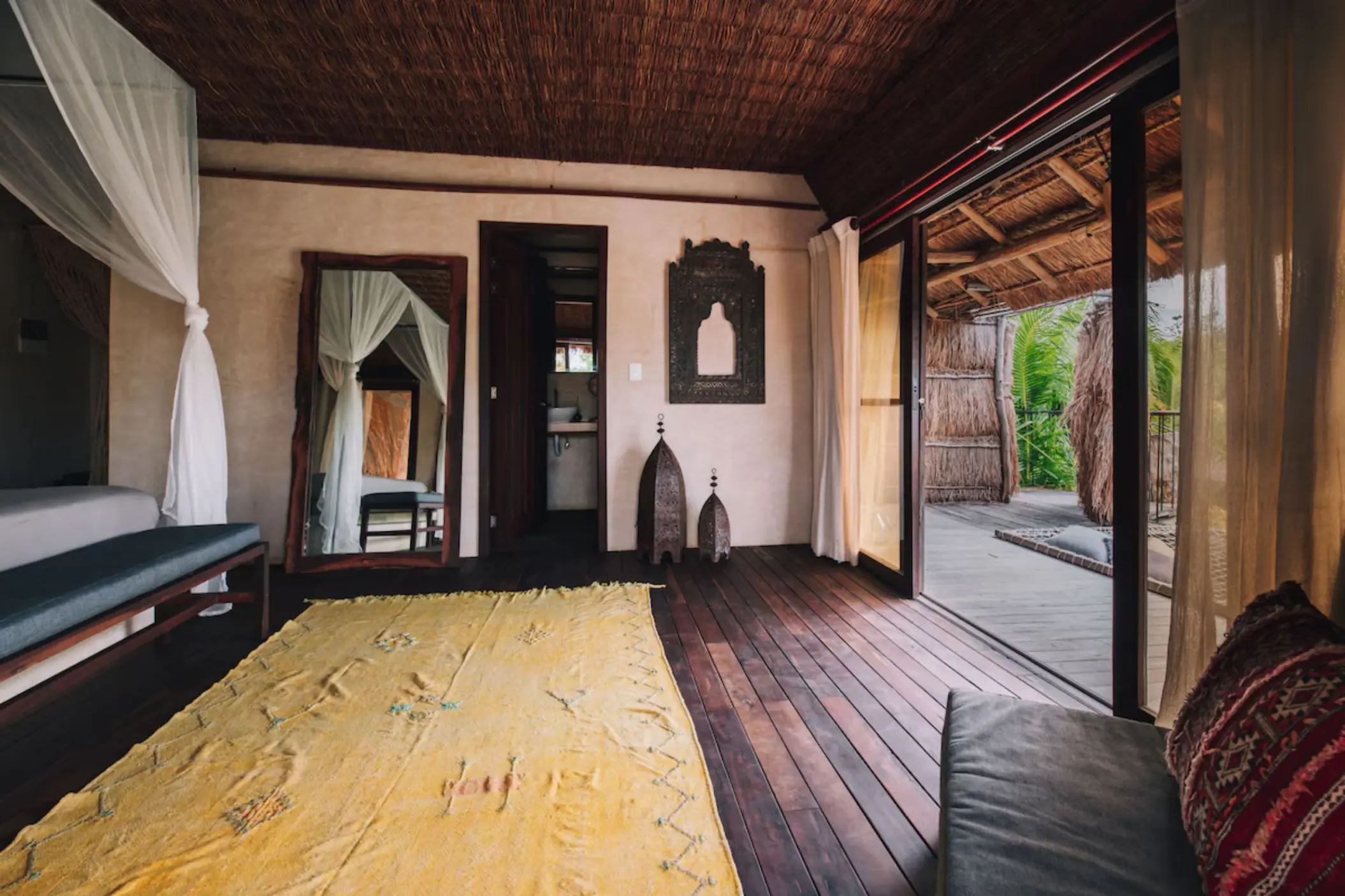 Cozy suite at Radhoo Tulum with earthy tones, wooden accents, and soft linens for a serene jungle escape.