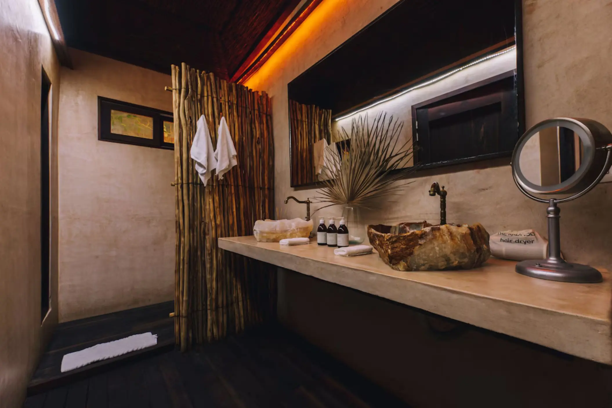 Artisanal stone washbasin at Radhoo Tulum with eco-friendly toiletries and minimal jungle-inspired decor.
