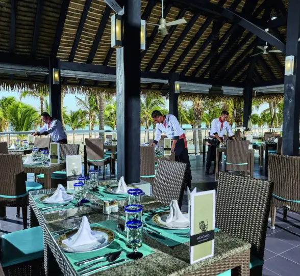 An elegant buffet restaurant with multiple food counters, decorative wall art, and a high ceiling.
