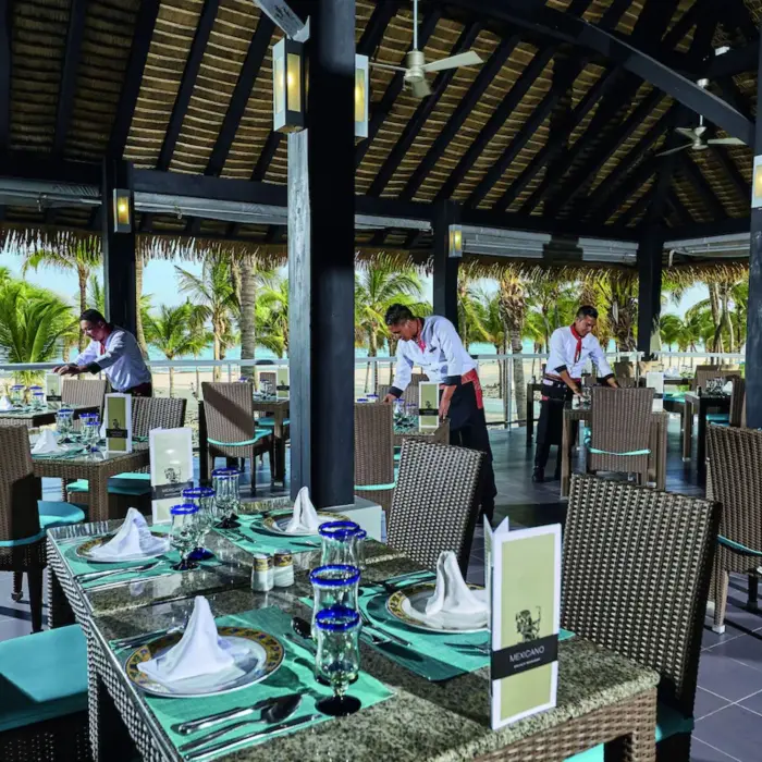 An elegant buffet restaurant with multiple food counters, decorative wall art, and a high ceiling.
