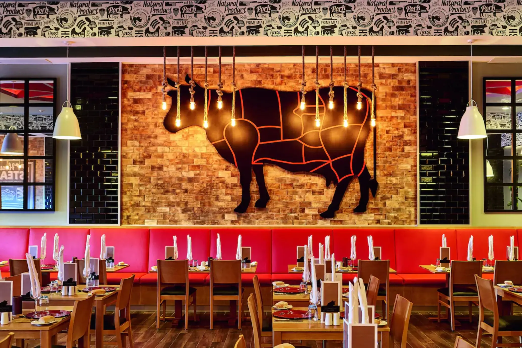 A steakhouse with dark wood tables, upholstered chairs, and a bar area.