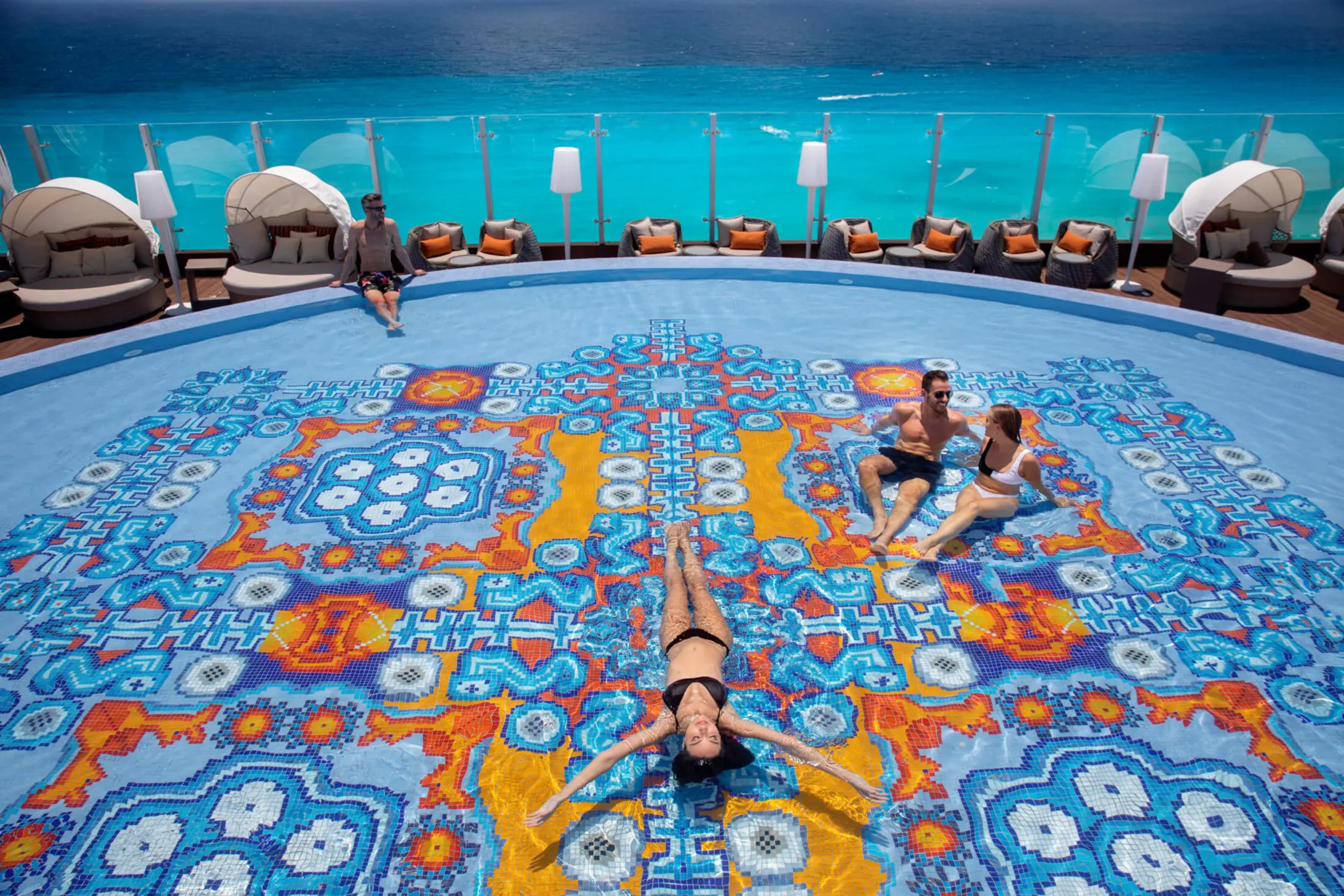 people lounging in and around the rooftop pool at Royalton CHIC Cancun
