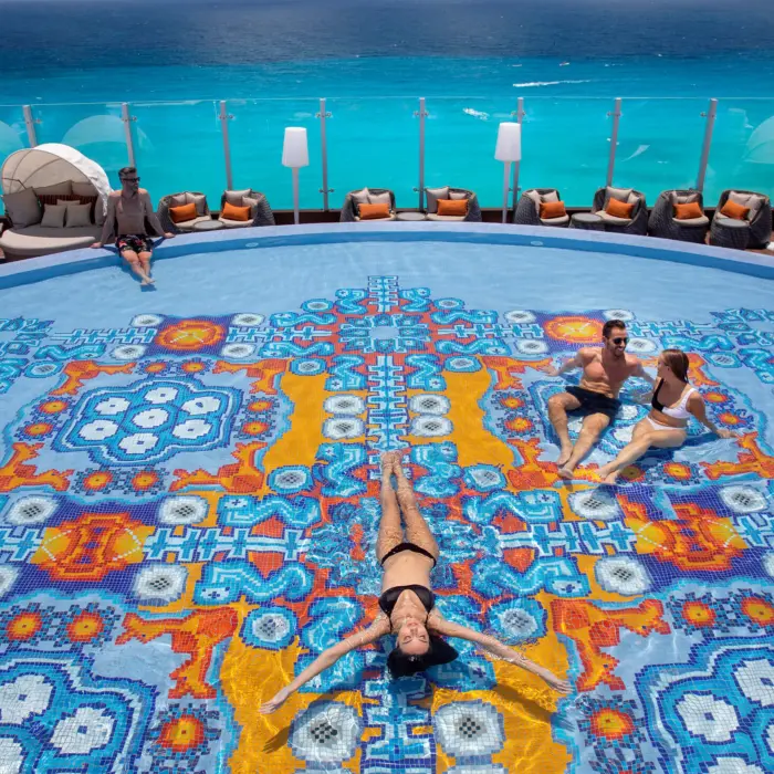 people lounging in and around the rooftop pool at Royalton CHIC Cancun