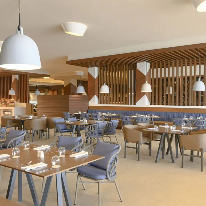 Bright buffet-style restaurant with wooden decor, pendant lights, and comfortable modern dining furniture.