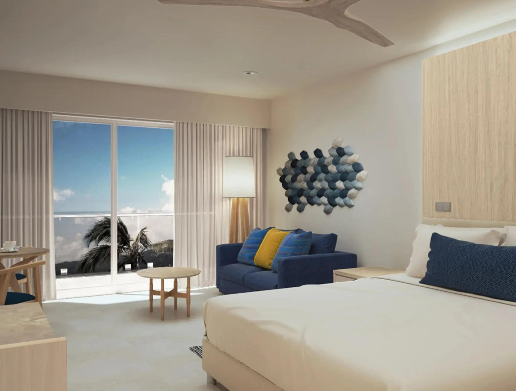 Bright and modern oceanview hotel suite with balcony, seating area, and coastal-inspired wall art.