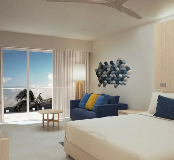 Bright and modern oceanview hotel suite with balcony, seating area, and coastal-inspired wall art.