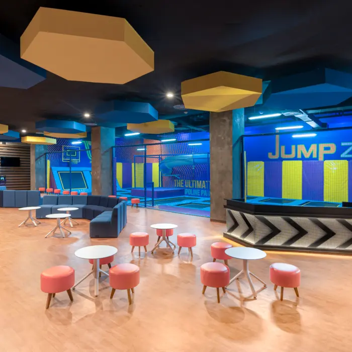Indoor trampoline park with padded floors, jump zones, and bright decor for kids and teens to play safely.