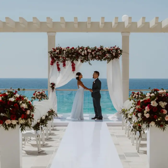 A bride and groom standing at the altar of a rooftop wedding ceremony with the Caribbean Sea as a backdrop.