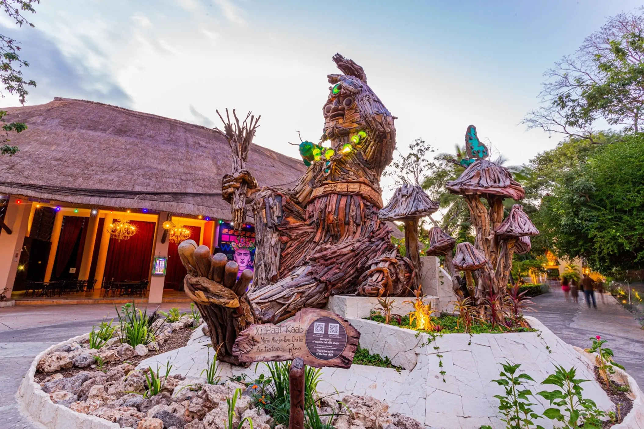 An impressive, large wooden art installation with green lights and butterflies at Sandos Caracol Eco Resort.