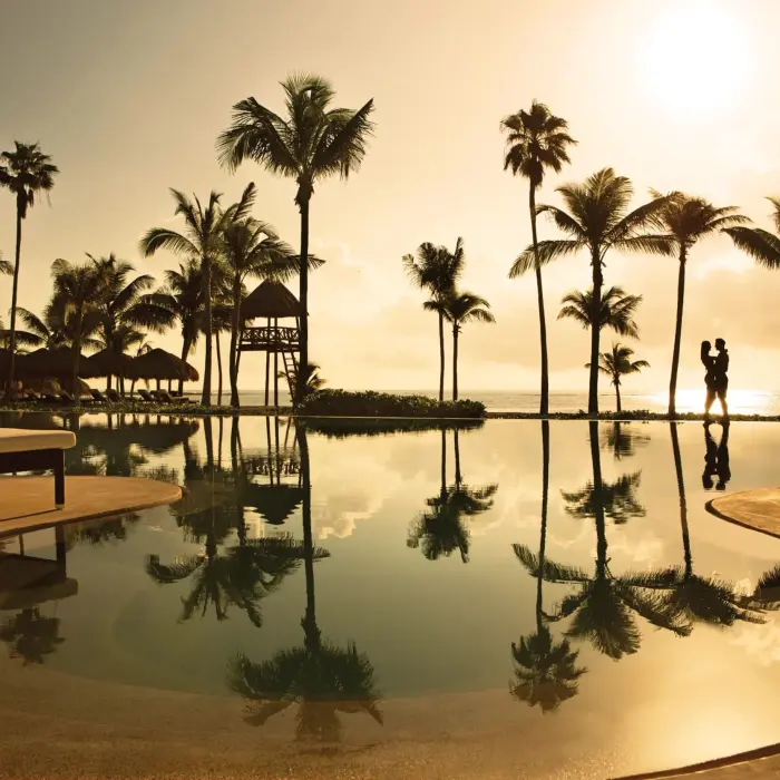 couple at the infinity pool during sunset at Secrets Akumal Riviera Maya