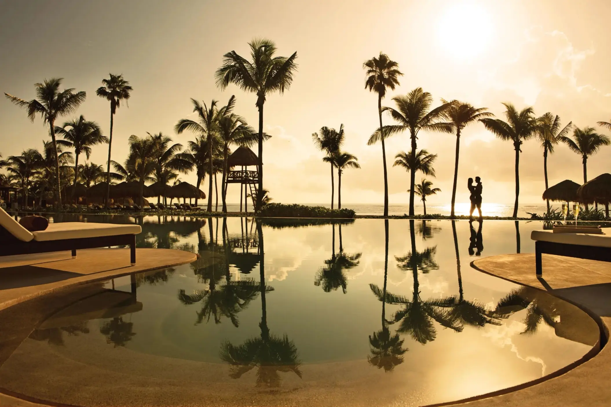 couple at the infinity pool during sunset at Secrets Akumal Riviera Maya