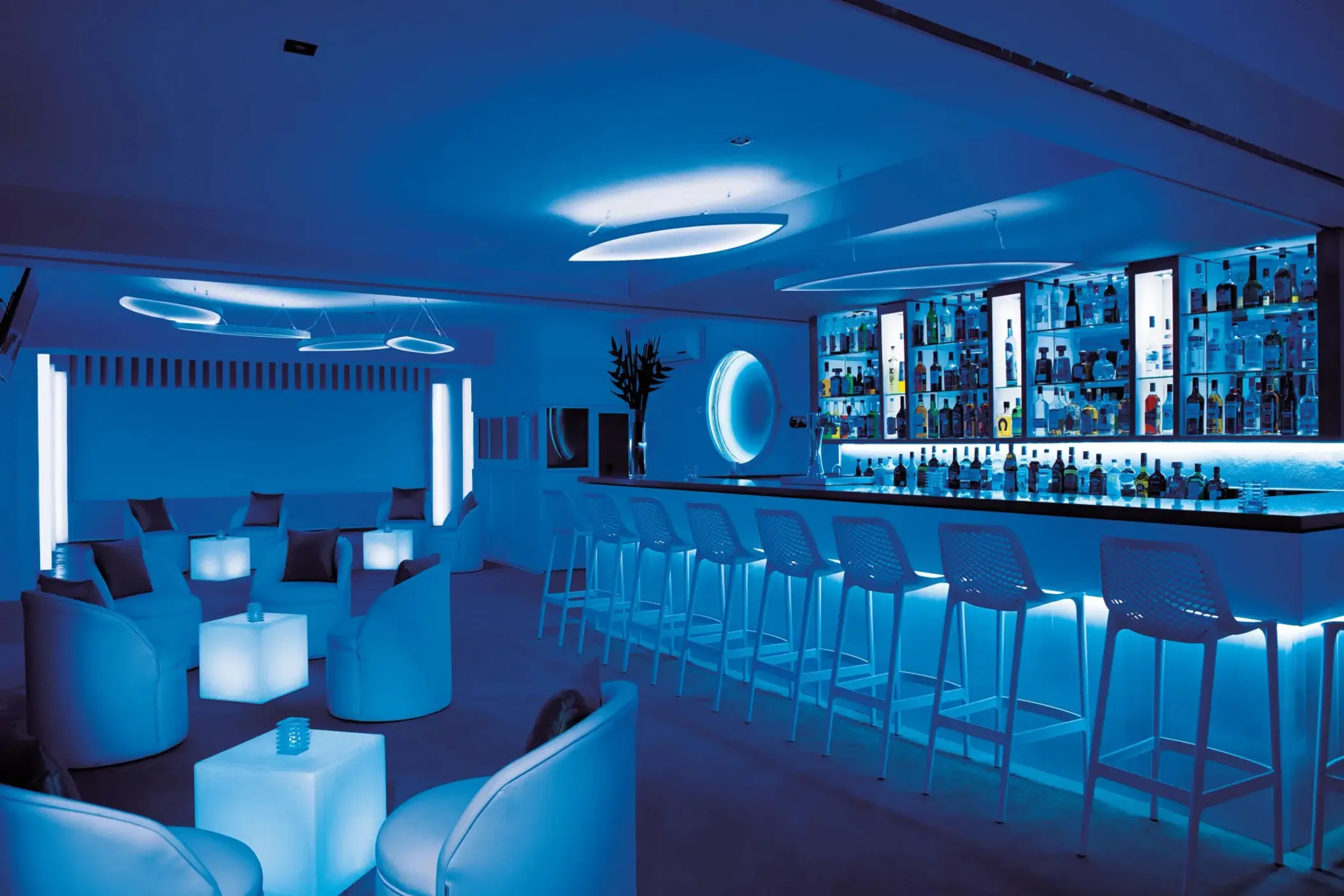 Chic nightclub-style bar with neon lighting, sleek seating, and contemporary decor for evening entertainment.
