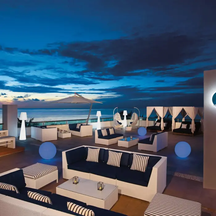Sky Bar with panoramic rooftop views, comfortable seating, and glowing accent lights for sunset cocktails.