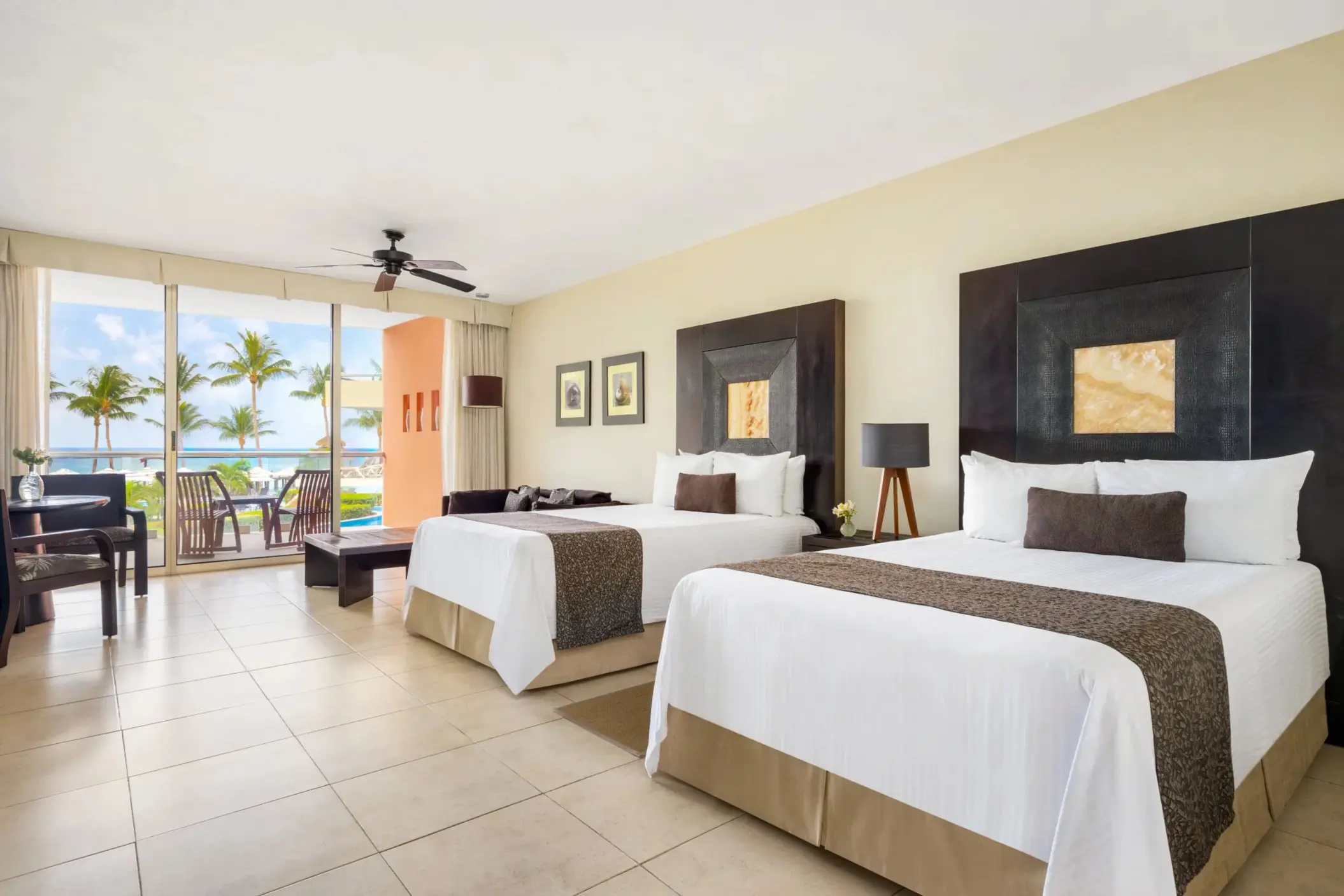 Spacious double-bed junior suite with ocean view balcony, modern decor, and seating area.