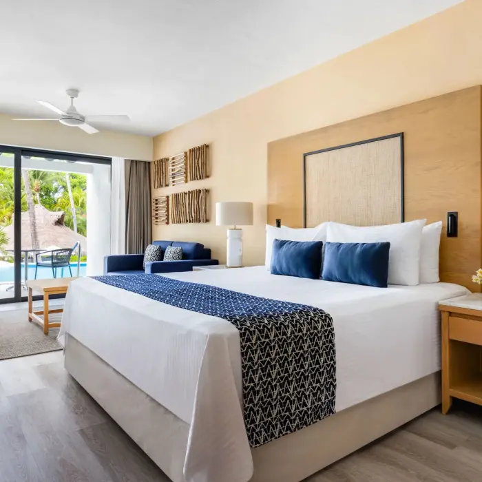 Swim-up junior suite with king bed, tropical decor, and direct pool access from private terrace.