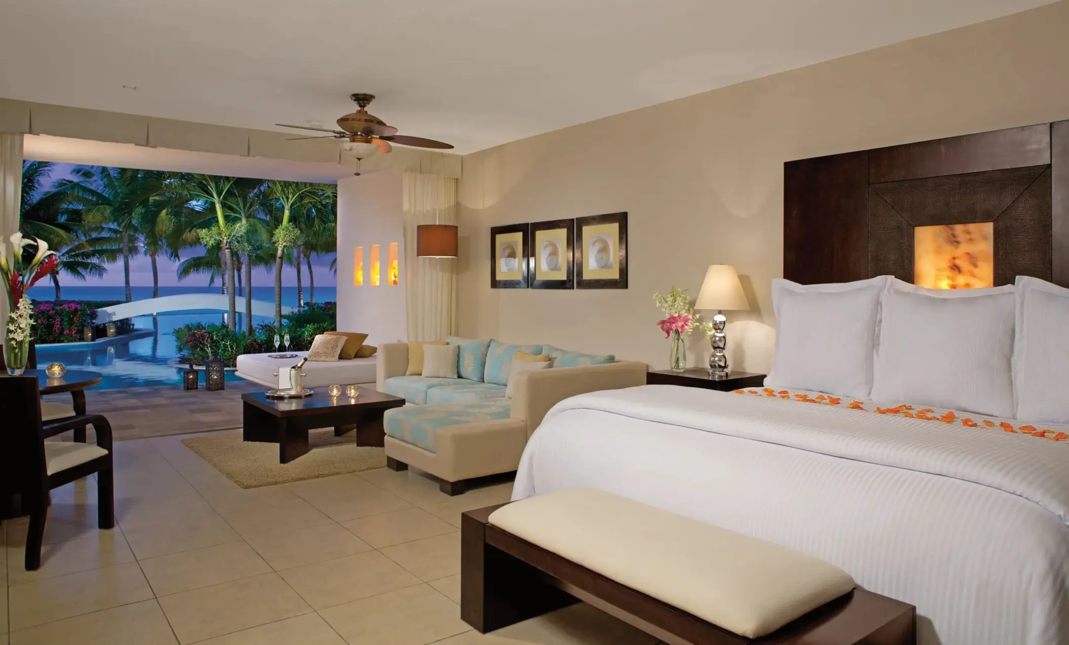 Romantic ocean view suite at night with private plunge pool, elegant bed, and cozy living area.