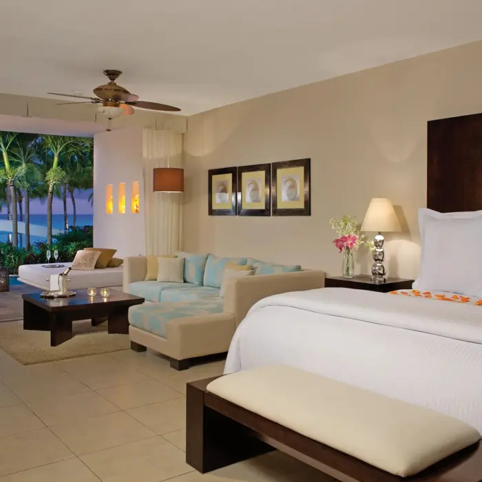 Romantic ocean view suite at night with private plunge pool, elegant bed, and cozy living area.