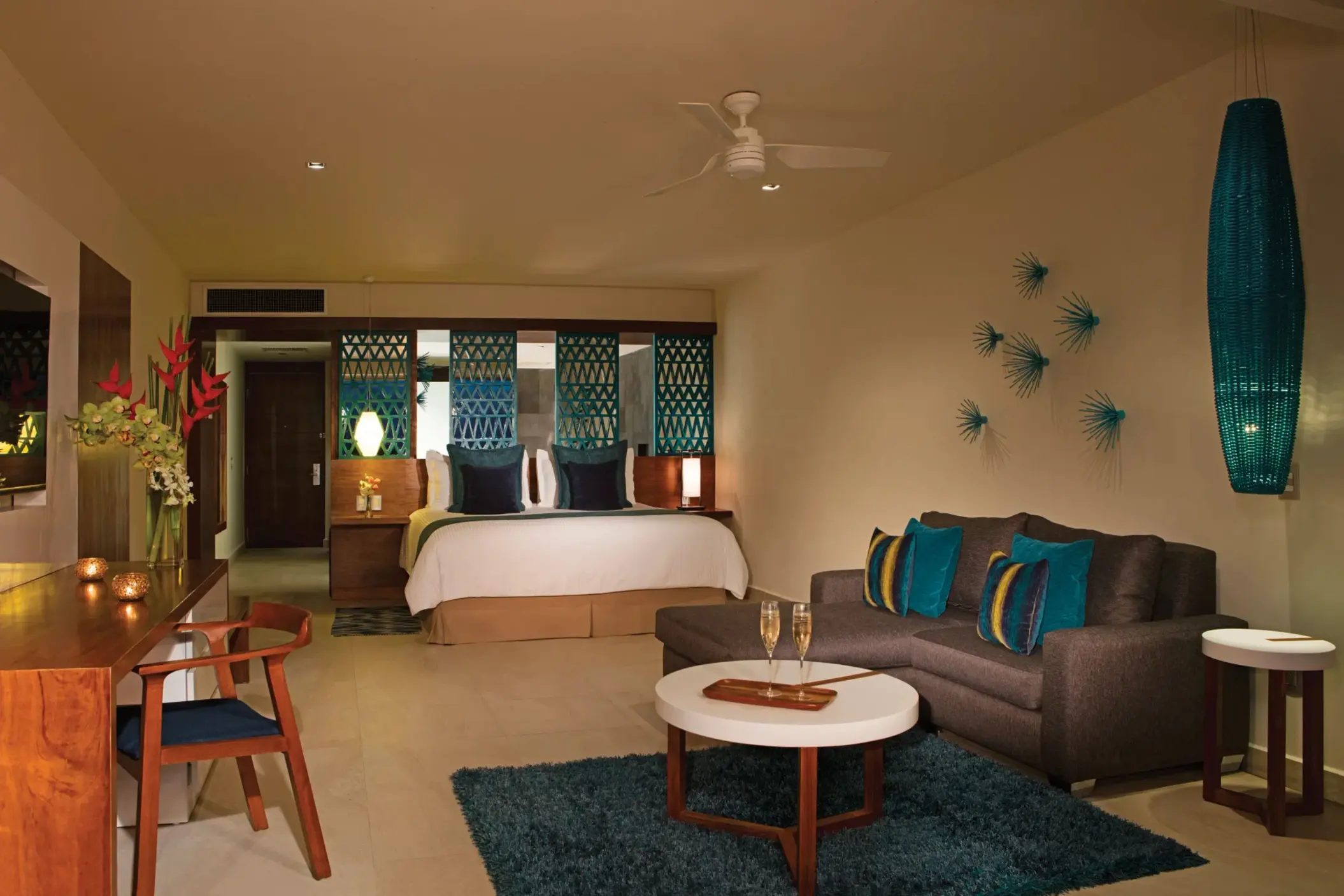 Spacious ocean view bedroom with teal accents, king bed, and cozy seating area in modern decor.