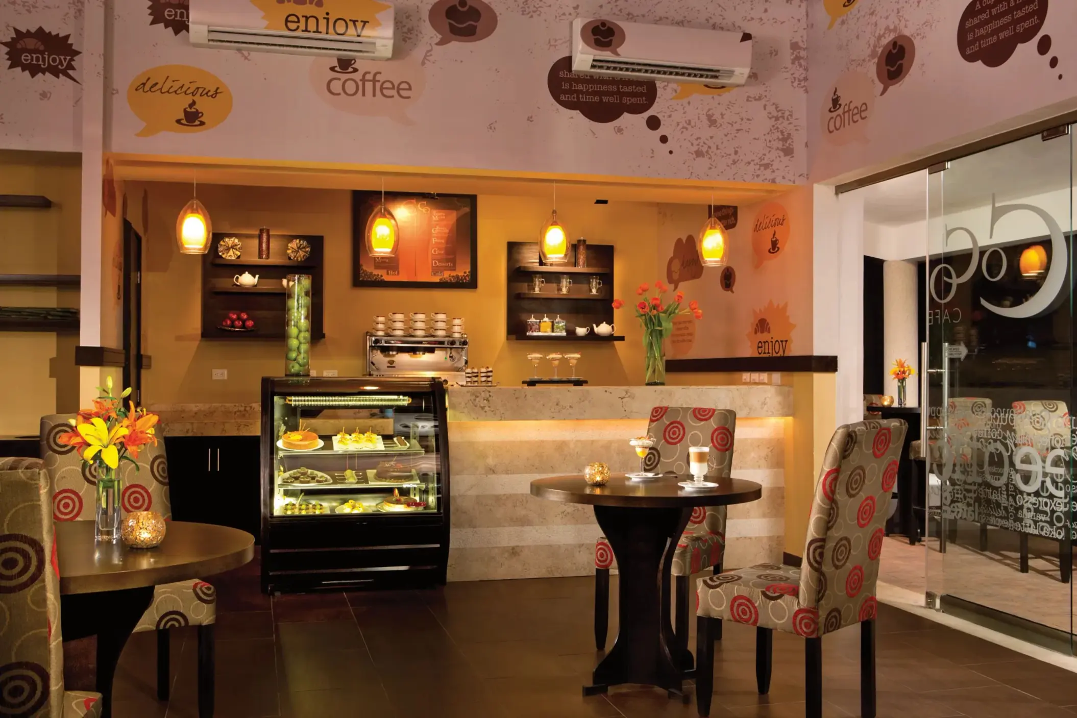 Cozy Coco Café with wooden furniture, pendant lighting, and a display of fresh pastries and coffee.