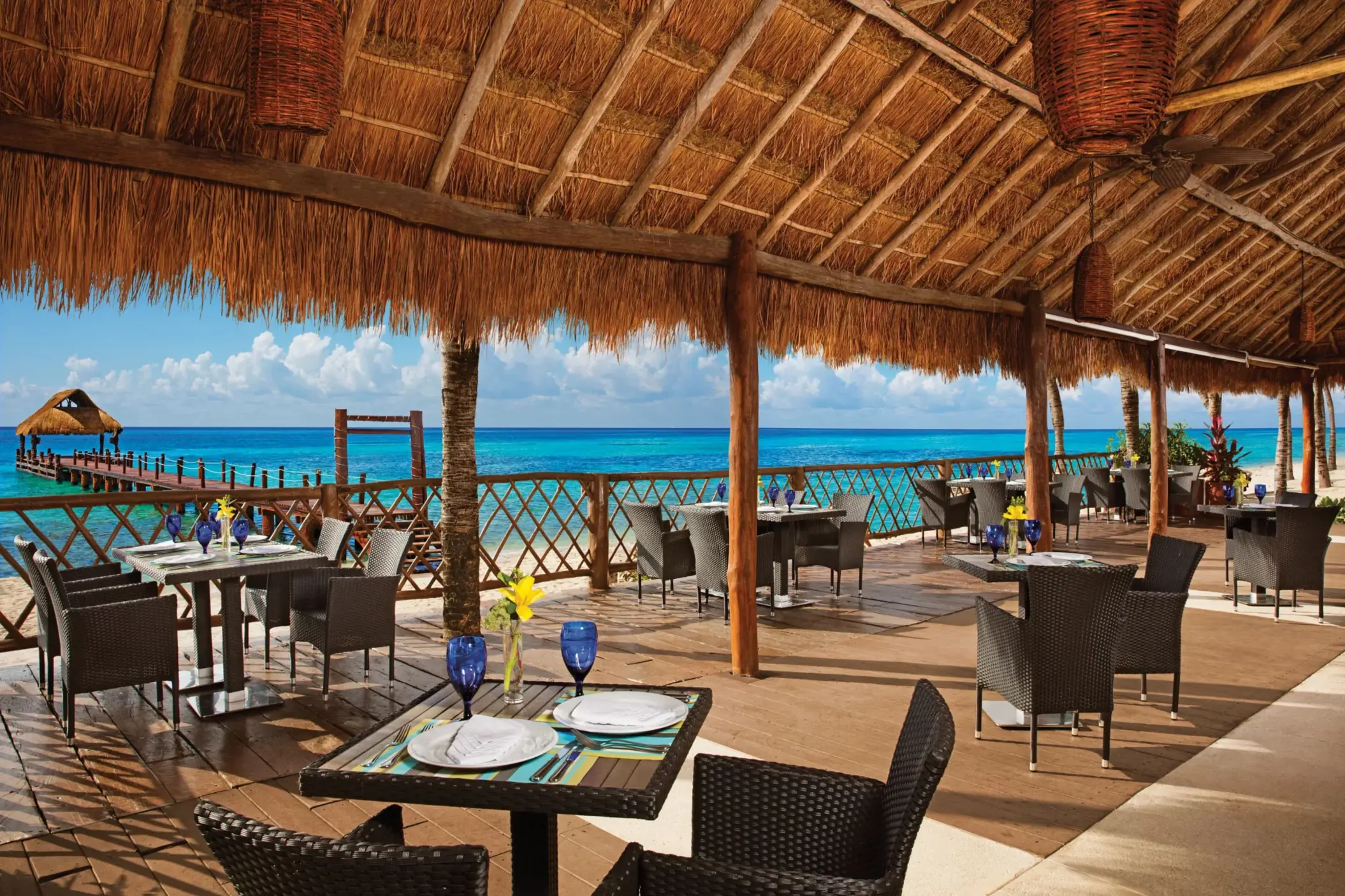 Elegant outdoor dining at Oceana with white tablecloths, ocean breeze, and Caribbean Sea views.