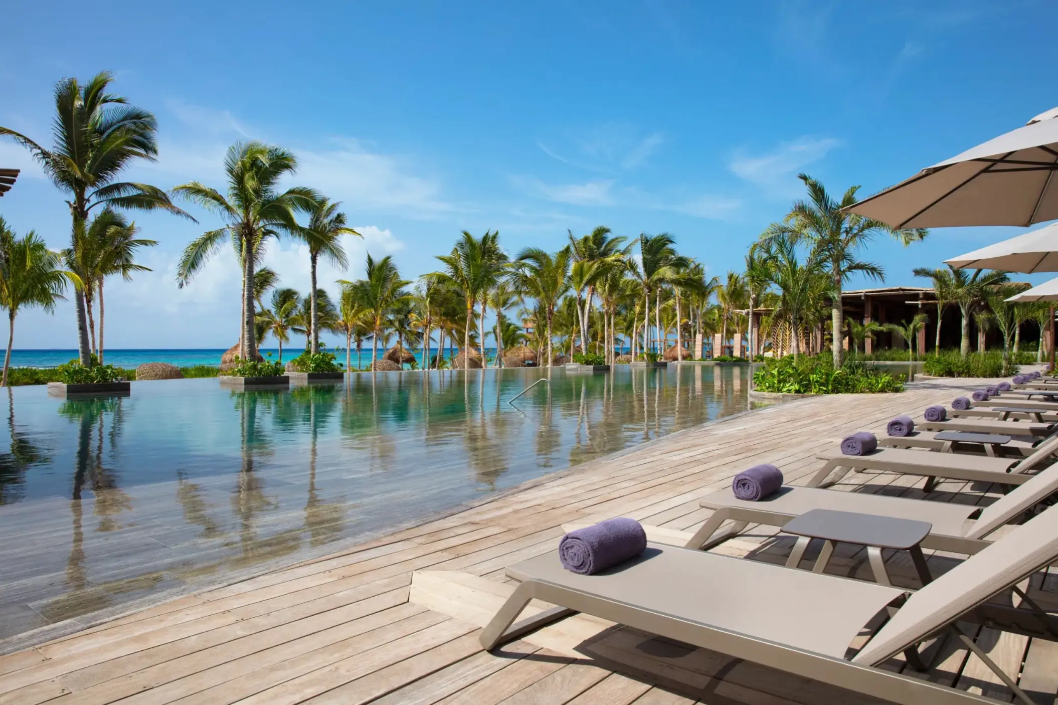 main infinity pool by the beach with loungers at Secrets Moxche Playa Del Carmen