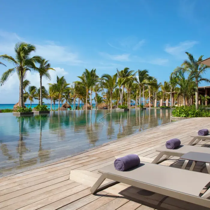 main infinity pool by the beach with loungers at Secrets Moxche Playa Del Carmen